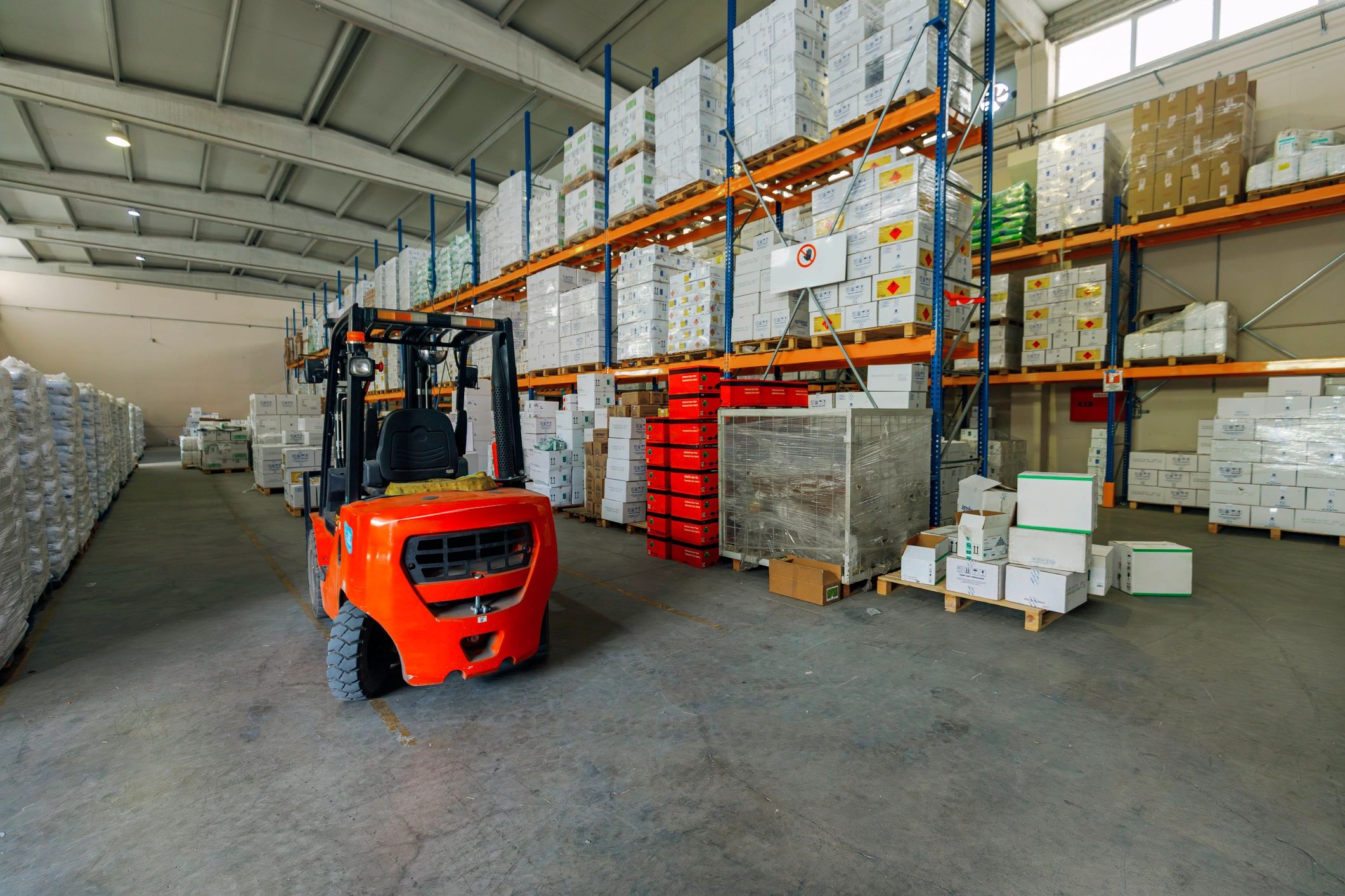 Forklift moving pallets in a warehouse aisle