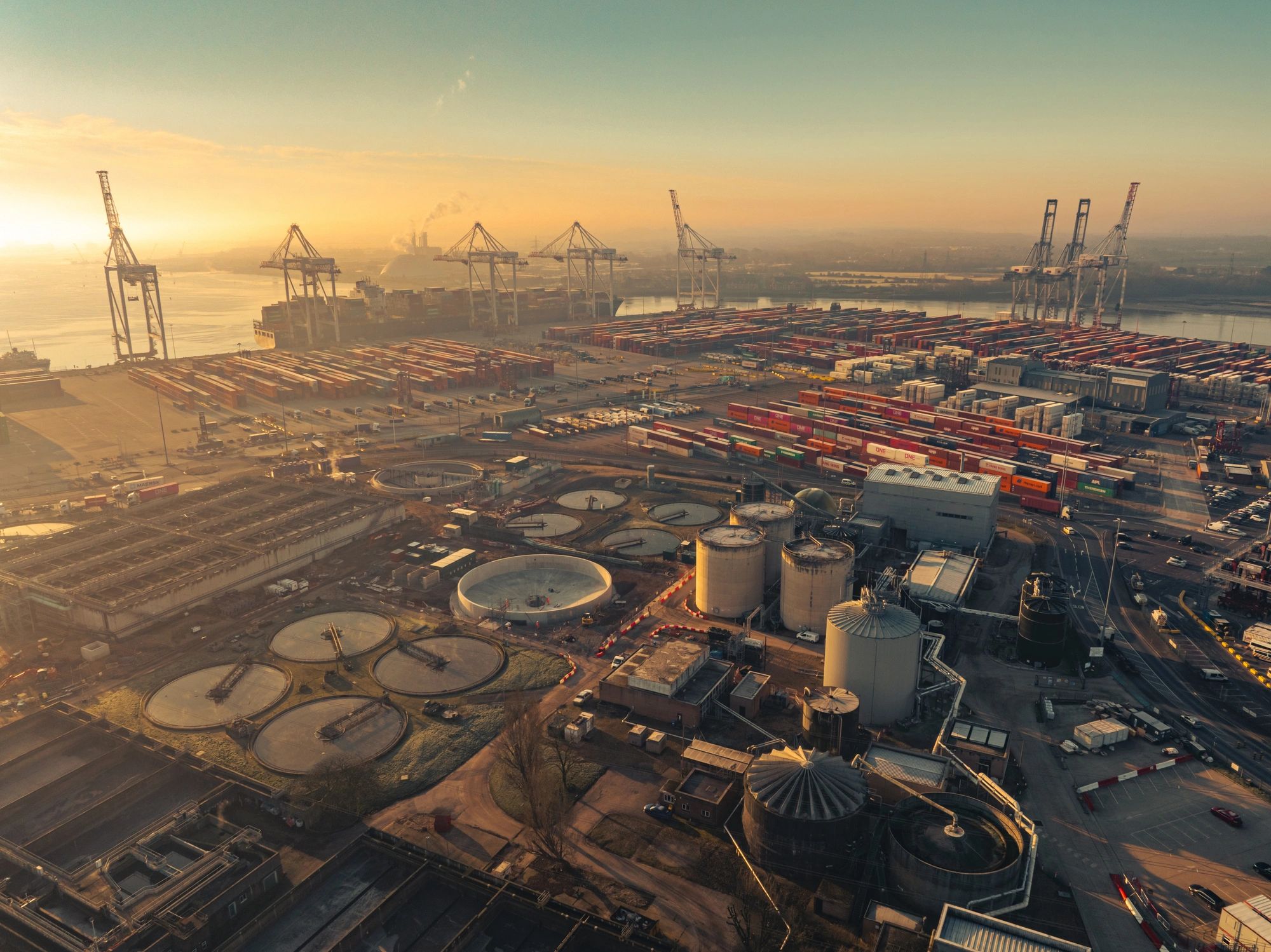 Container terminal at sunset with cranes and stacked containers
