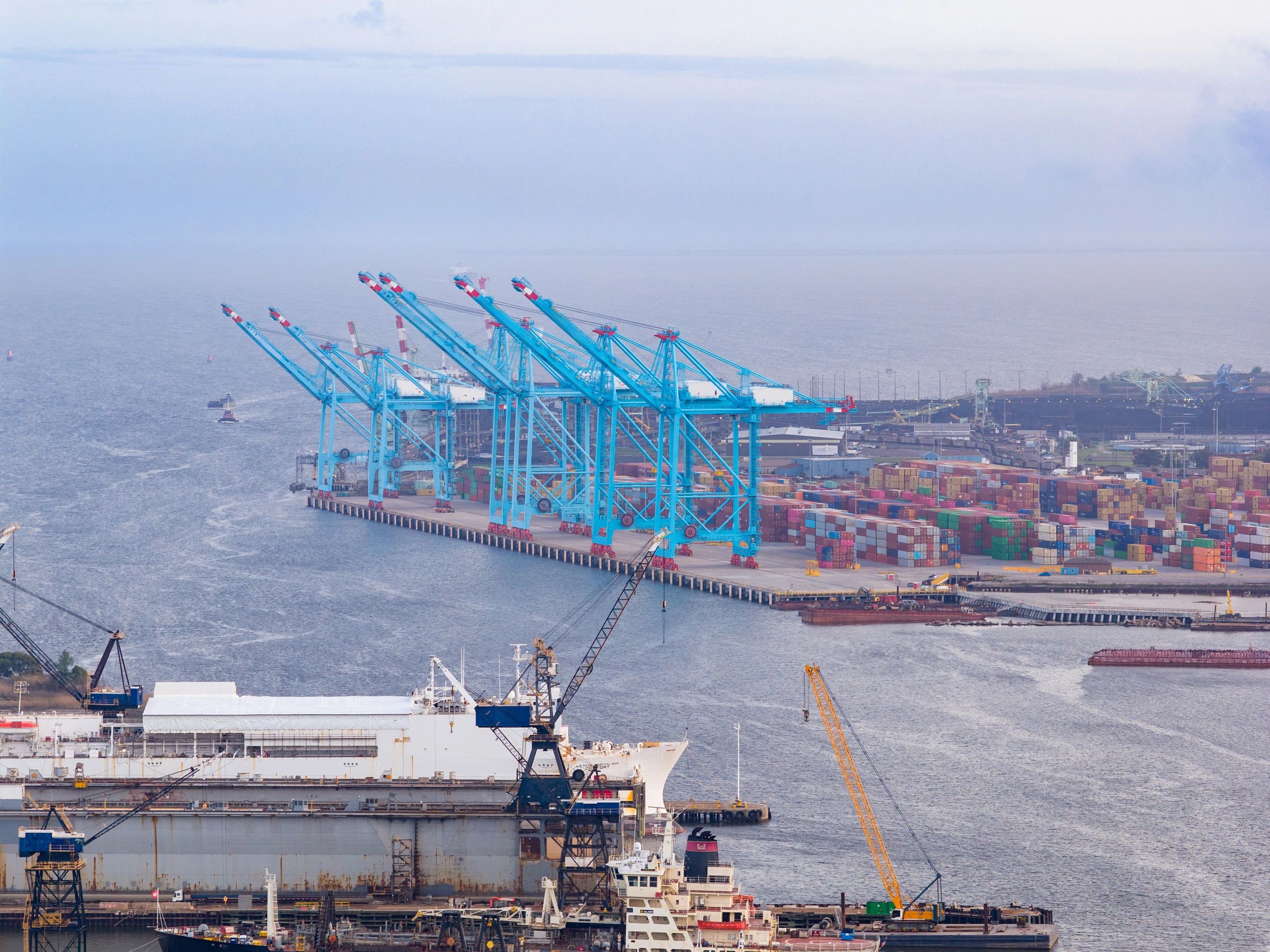 Aerial view of a busy container port with cranes and ships
